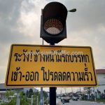 สัญญาณไฟกระพริบ พร้อมป้าย "ระวัง! ข้างหน้ามีรถบรรทุก เข้า-ออก..." บริษัท โตโยต้า มอเตอร์ ประเทศไทย จํากัด โรงงานบางปะกง